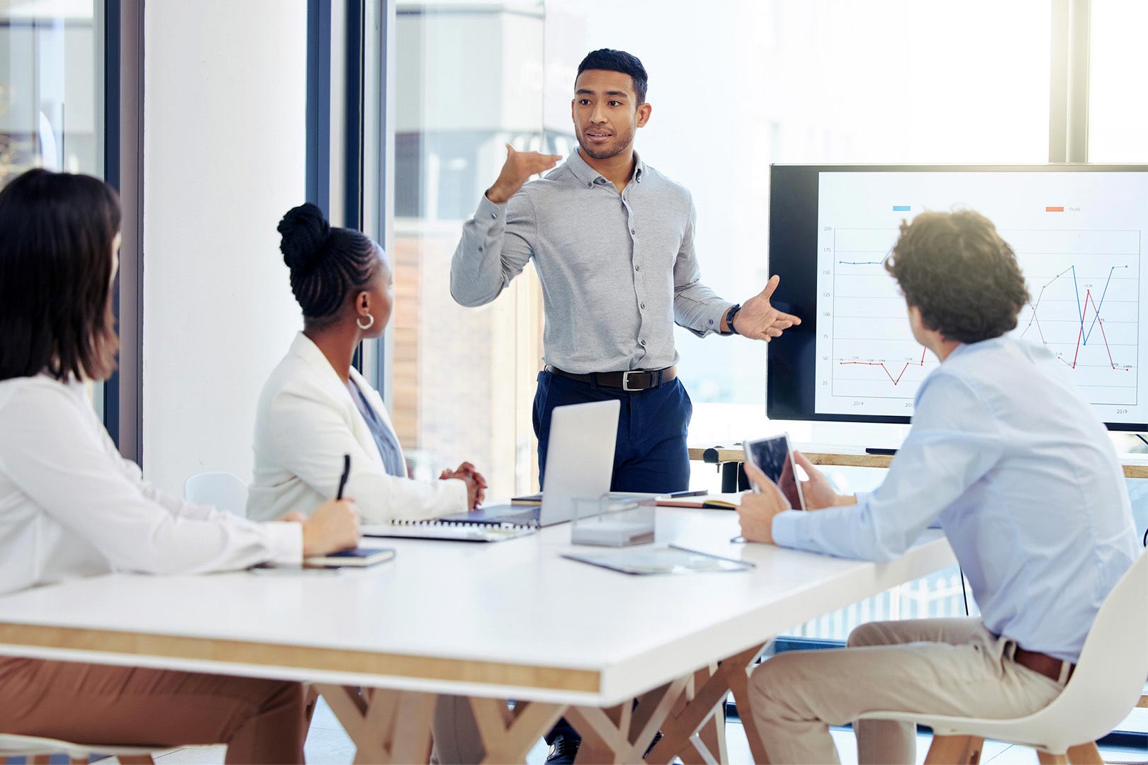 A man presenting figures to a group of people