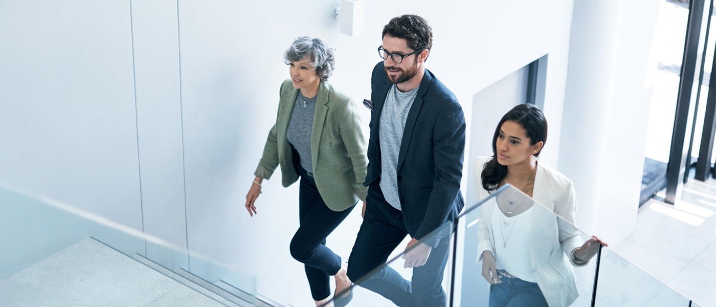 Three people walking up stairs