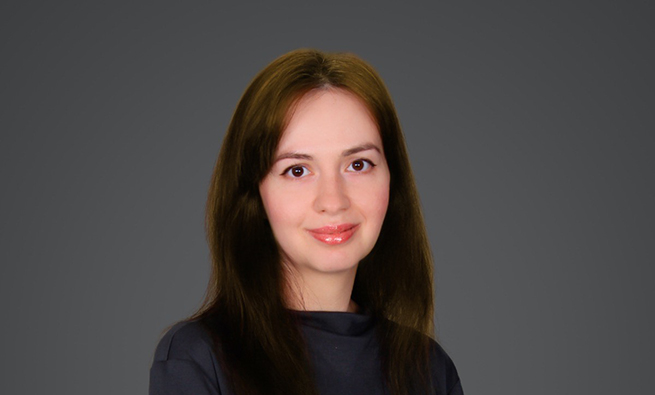 Woman with brown hair, brown eyes and white skin, looking at the camera against grey background