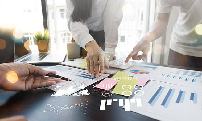 Group of people in office looking at notes on a table