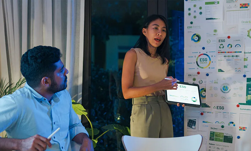 A woman giving a presentation holding a tablet computer